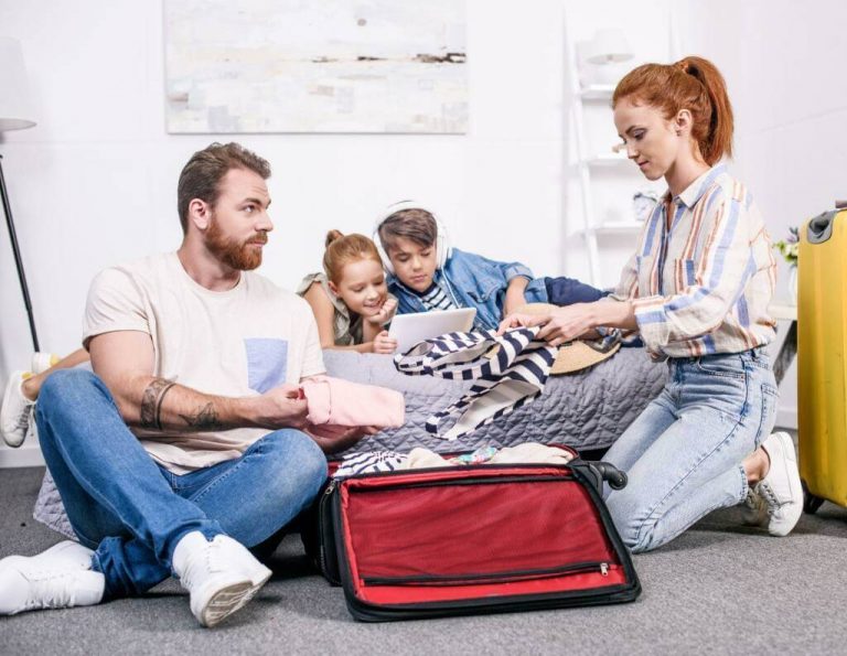 family with insurance packing suitcase